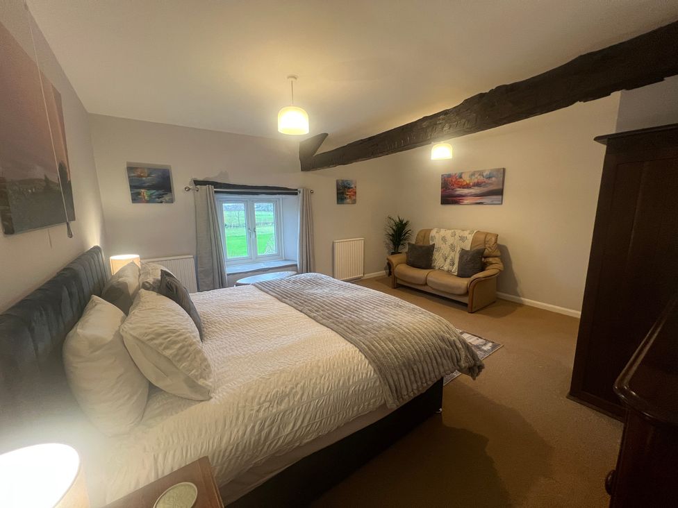 A bedroom with a bed and sofa at The Old Farmhouse at Brackenthwaite Farm Yealand Redmayne near Arnside