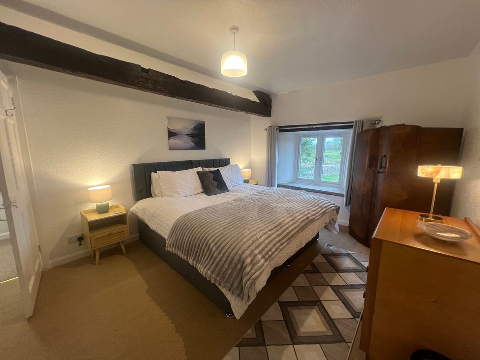 A bedroom with a double bed and window at The Old Farmhouse at Brackenthwaite Farm Yealand Redmayne near Arnside