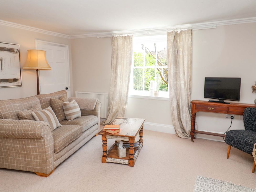 A living room with a sofa and television at Beehive in Beccles