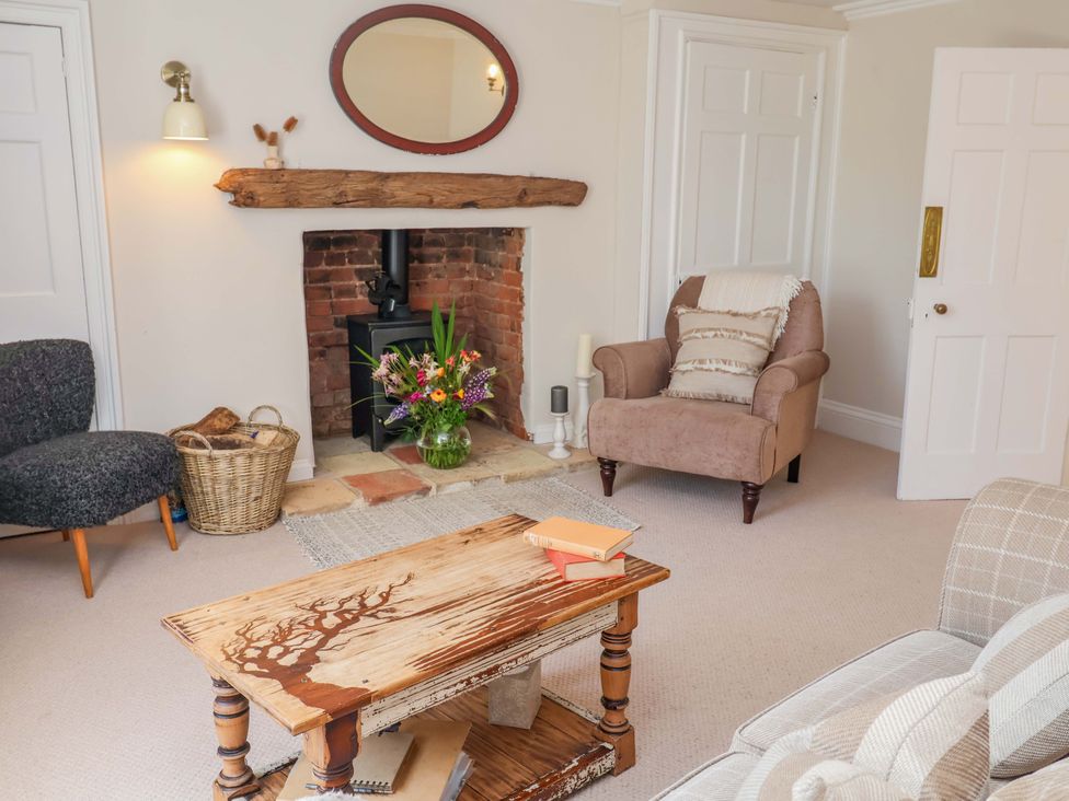 A living room with a fireplace and furniture at Beehive in Beccles