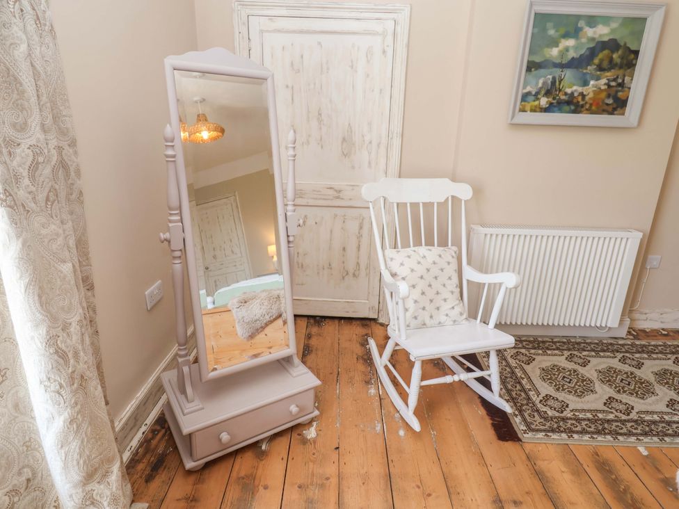 A room with a mirror and rocking chair at Beehive in Beccles
