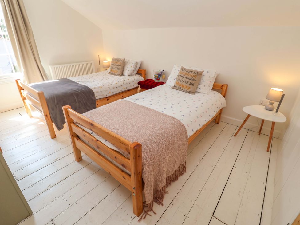 A bedroom with two beds and a lamp at Beehive in Beccles