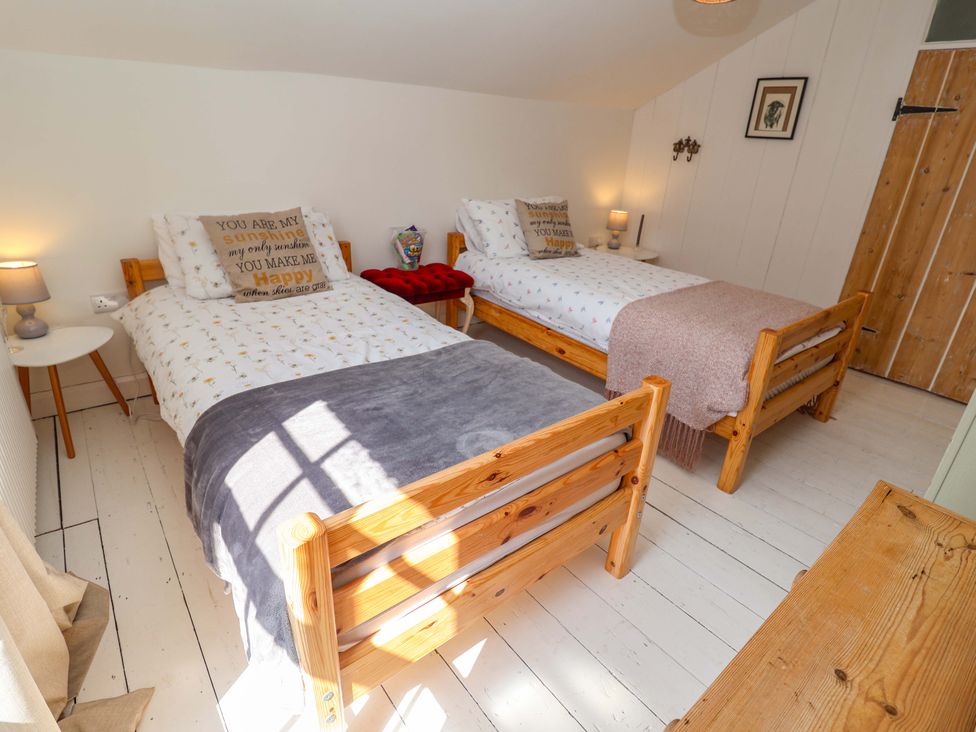 A bedroom with two beds and a wooden chest of drawers at Beehive in Beccles