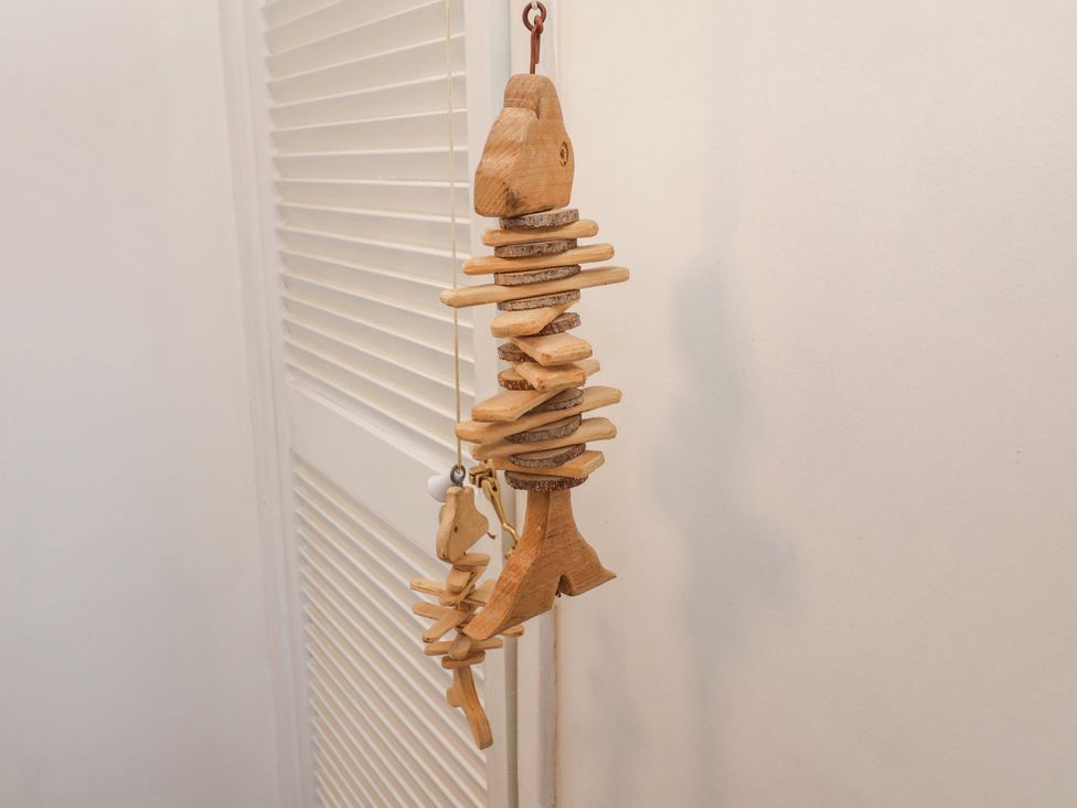 A wooden fish decoration hanging on a wall at Beehive in Beccles