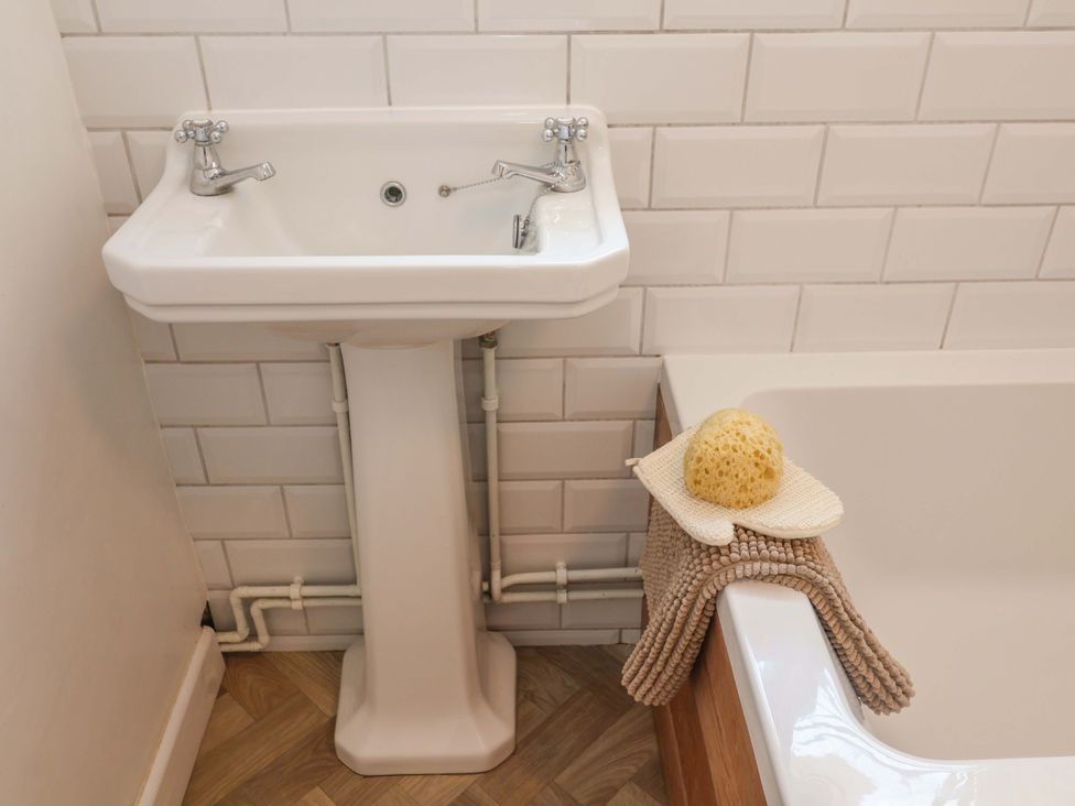 A sink with faucets and a towel in a bathroom at Beehive in Beccles