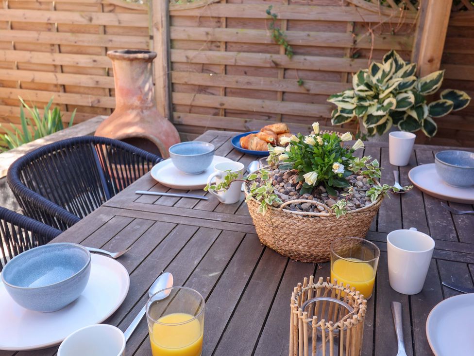 An outdoor dining table set with croissants and drinks at Beehive in Beccles