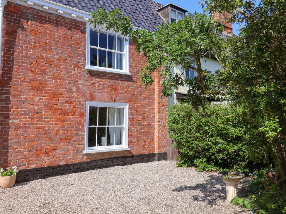 An exterior view of a brick wall with a window and plants at Beehive in Beccles