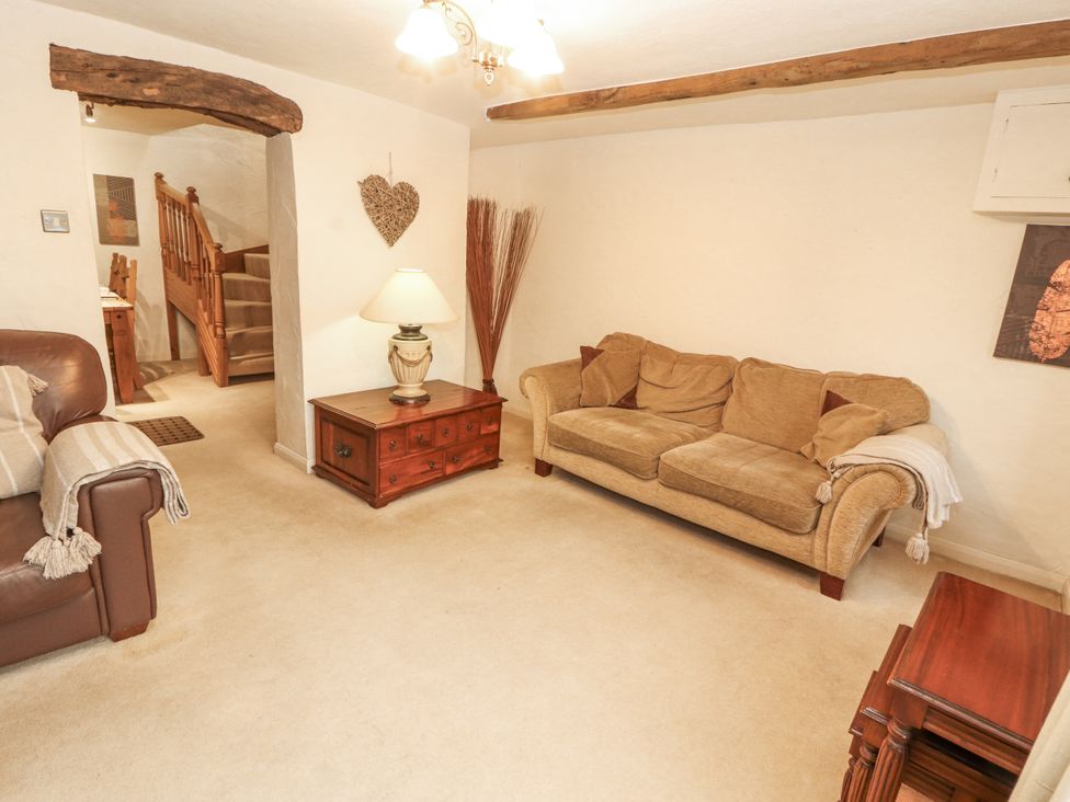 A living room with a sofa and lamp at 2 Bens Row near Backbarrow