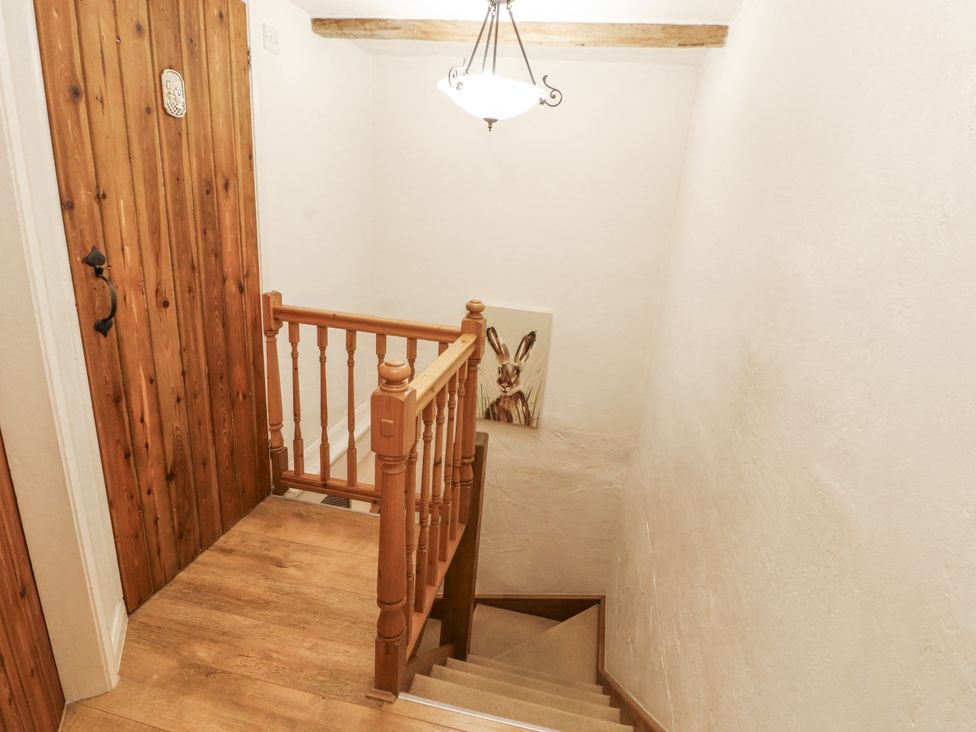 A staircase featuring wooden door and artwork at 2 Bens Row Backbarrow near Newby Bridge