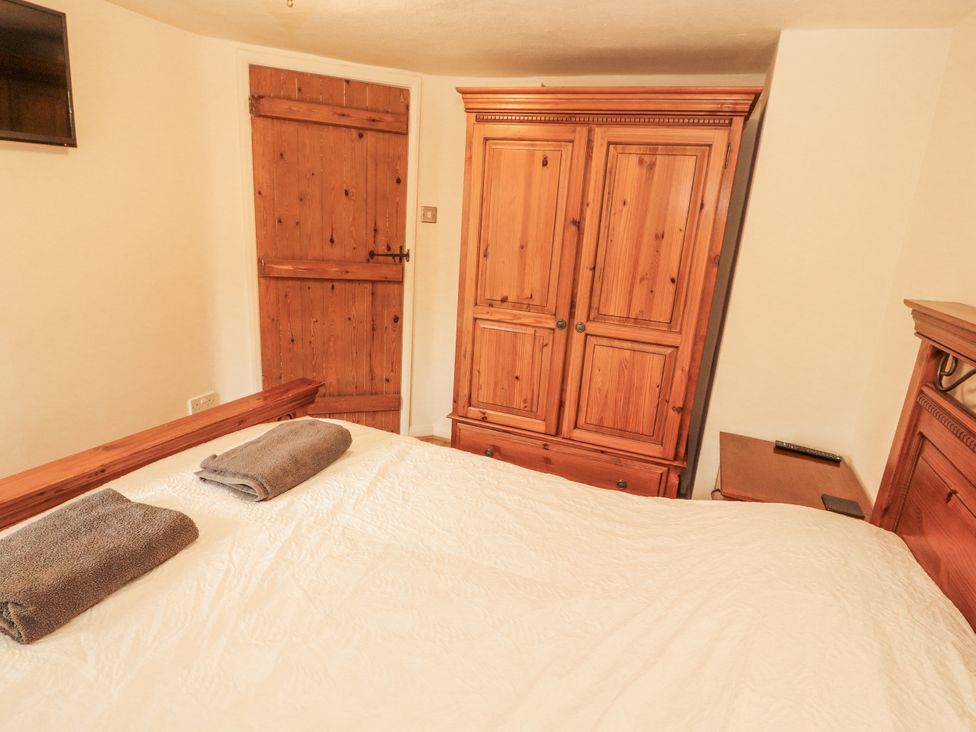 A bedroom with a bed and wardrobe at 2 Bens Row near Newby Bridge
