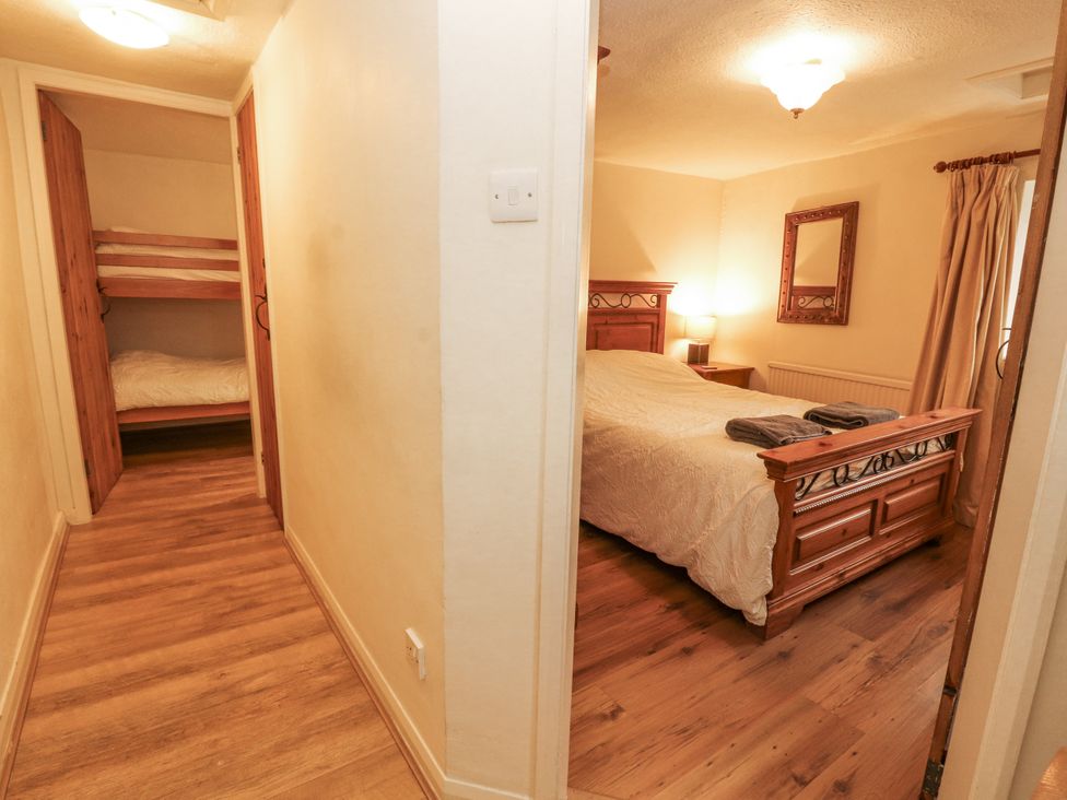 A bedroom with a double bed and bunk beds at 2 Bens Row Backbarrow near Newby Bridge