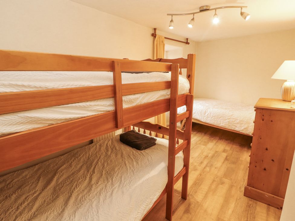 A bedroom with bunk bed and single bed at 2 Bens Row in Backbarrow near Newby Bridge
