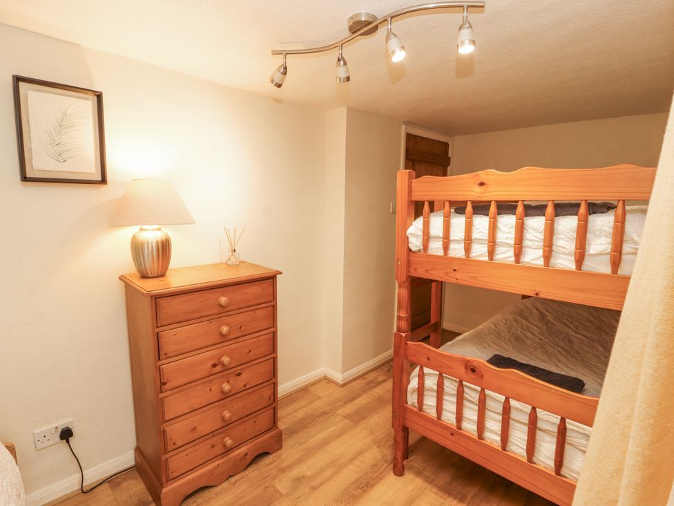 A bedroom with a bunk bed and a dresser at 2 Bens Row Backbarrow near Newby Bridge