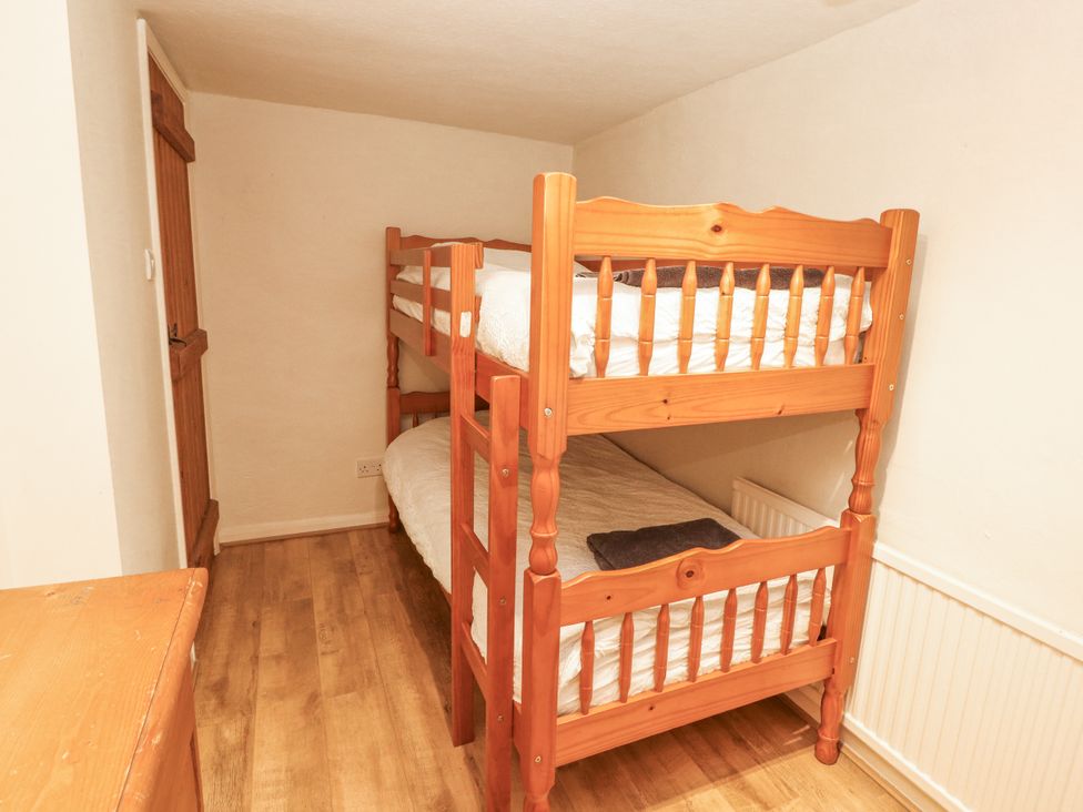 A bedroom with a bunk bed and wooden dresser at 2 Bens Row, Backbarrow near Newby Bridge