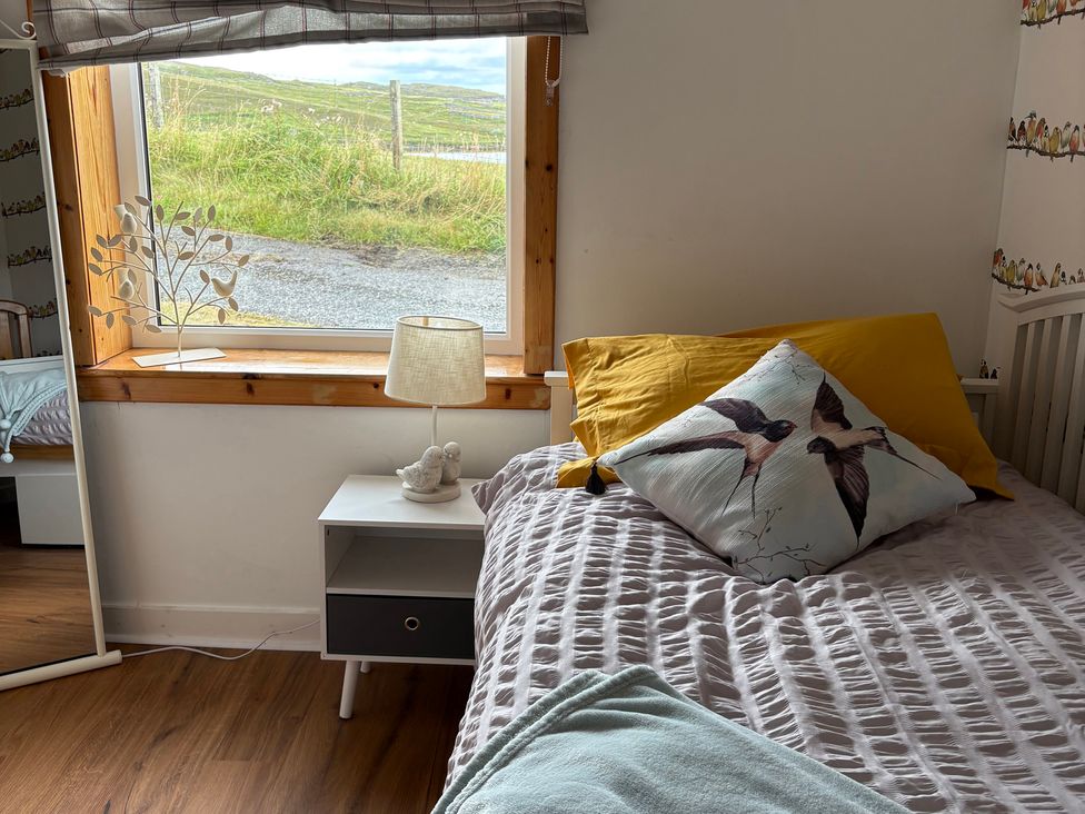 A bedroom with a bed and bedside table at 11 Knock in Carloway