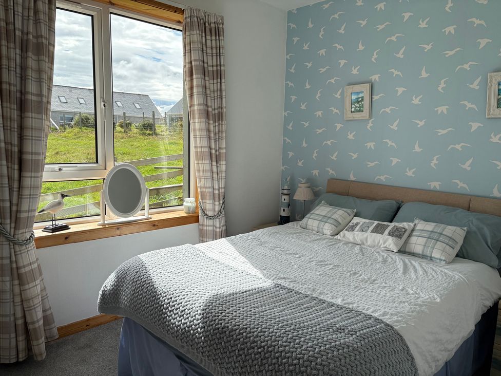 A bedroom with a bed and a window at 11 Knock in Carloway