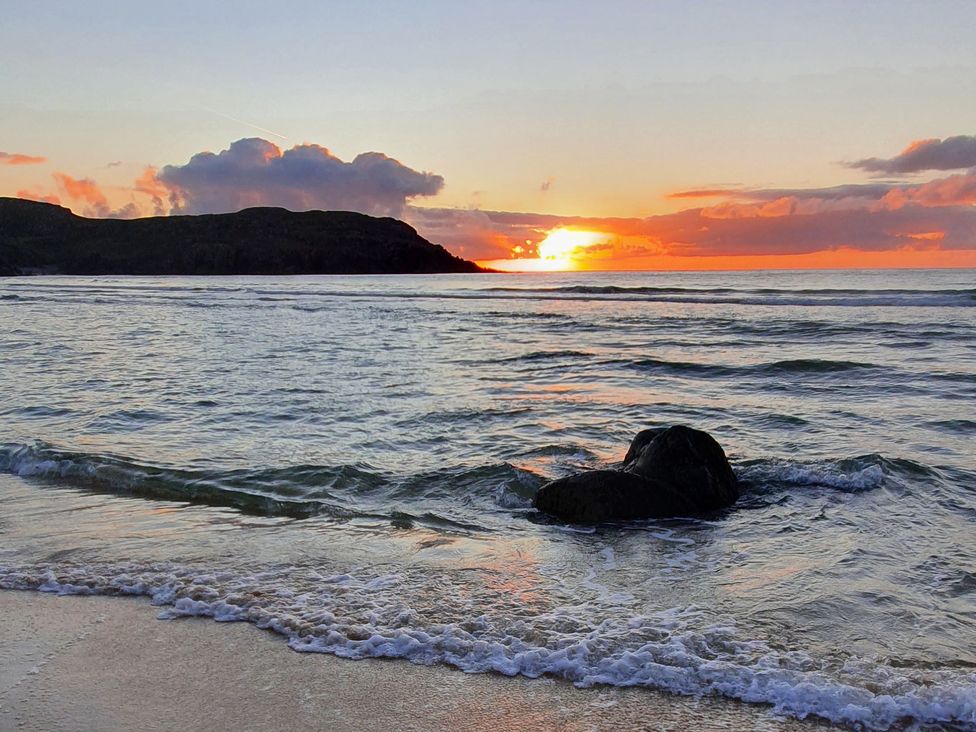 A scenic beach with a sunset and waves at 11 Knock in Carloway