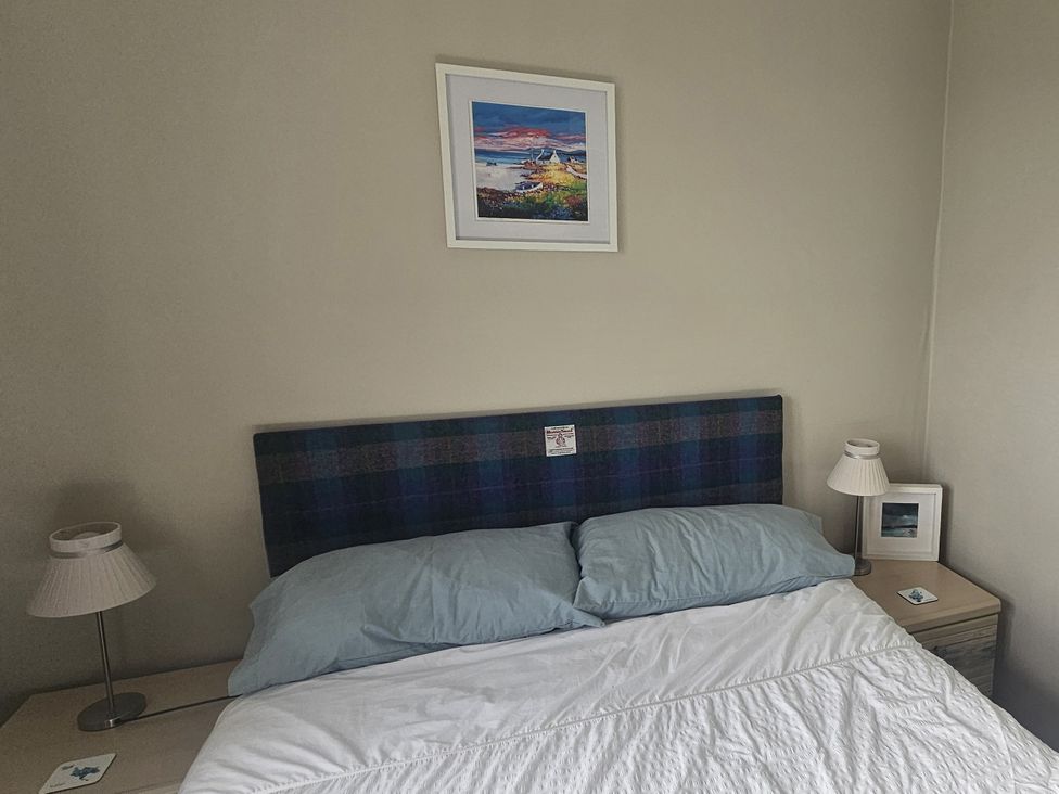 A bedroom with a bed and bedside lamp at 11 Knock in Carloway