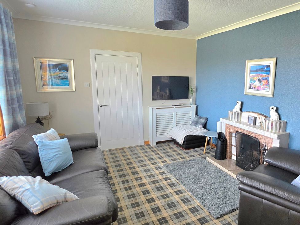 A living room with a sofa and television at 11 Knock in Carloway