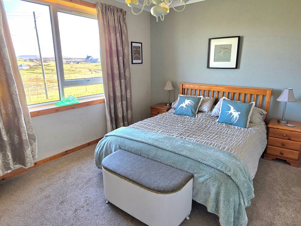 A bedroom with a bed and bedside tables at 11 Knock in Carloway