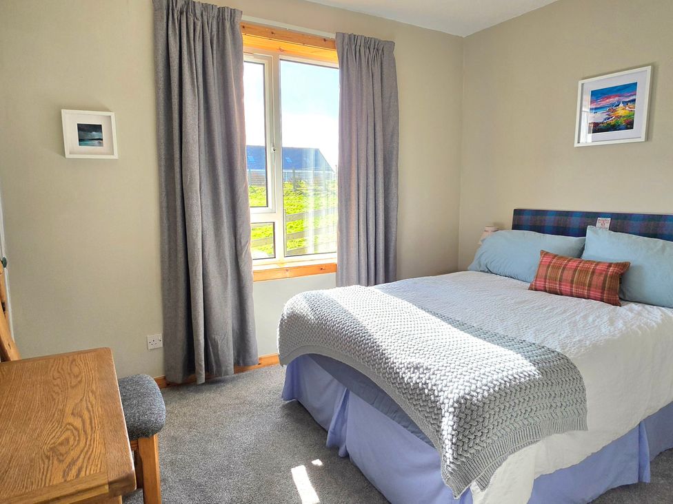 A bedroom with a bed and desk at 11 Knock in Carloway