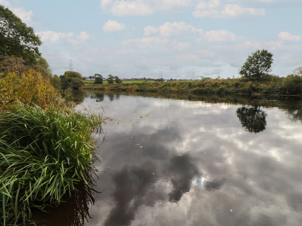 A river reflecting the sky and surrounded by grass and trees at Lodge 1 Stockton-on-Tees