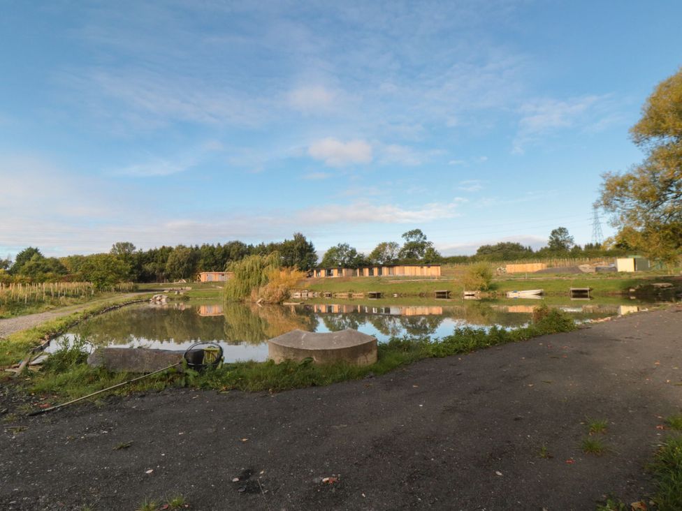 A pond surrounded by grass and trees at Lodge 2 Stockton-on-Tees