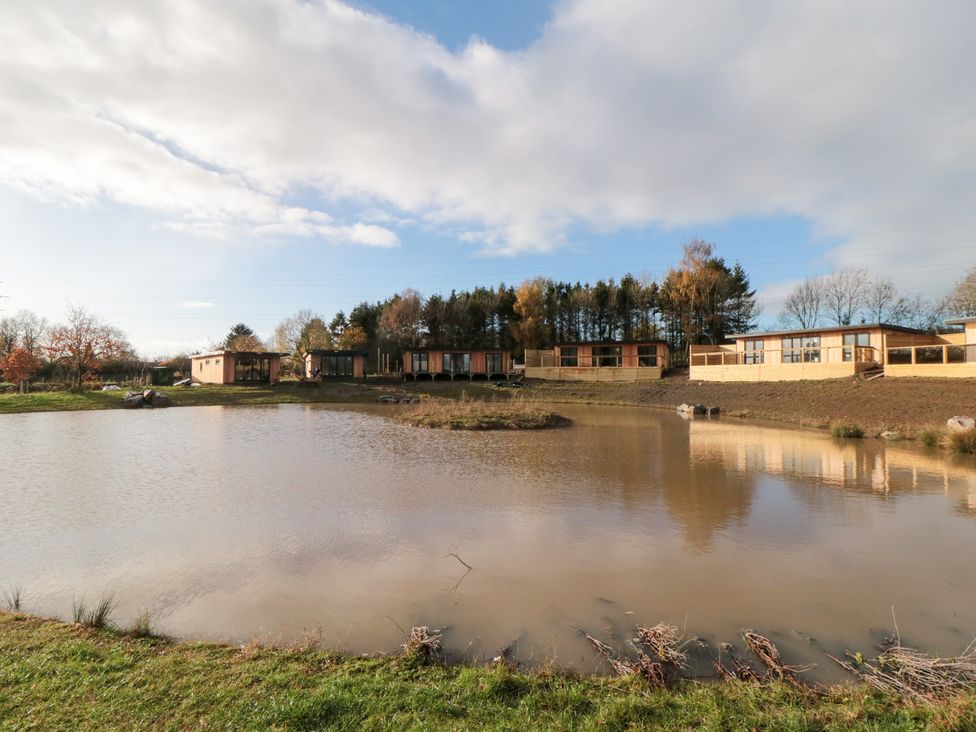 A view of the pond with buildings and trees at Lodge 3 Stockton-on-Tees