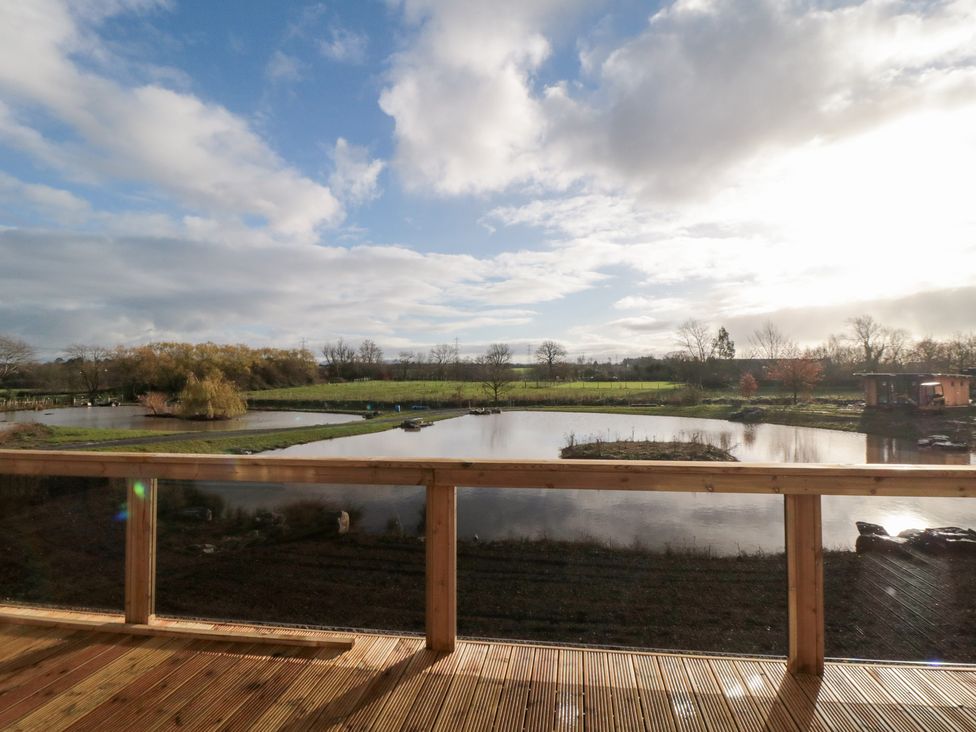 An outdoor area with decking overlooking a pond at Lodge 4 Stockton-on-Tees