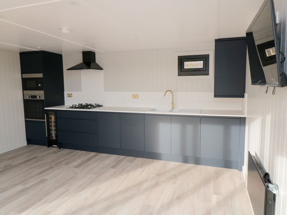 A kitchen with cabinets and appliances at Lodge 4 in Stockton-on-Tees