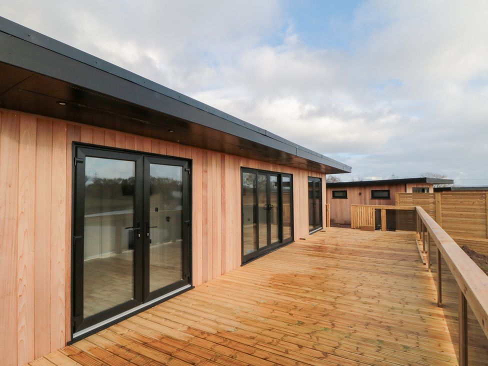 An outdoor deck area with glass doors at Lodge 5 Stockton-on-Tees