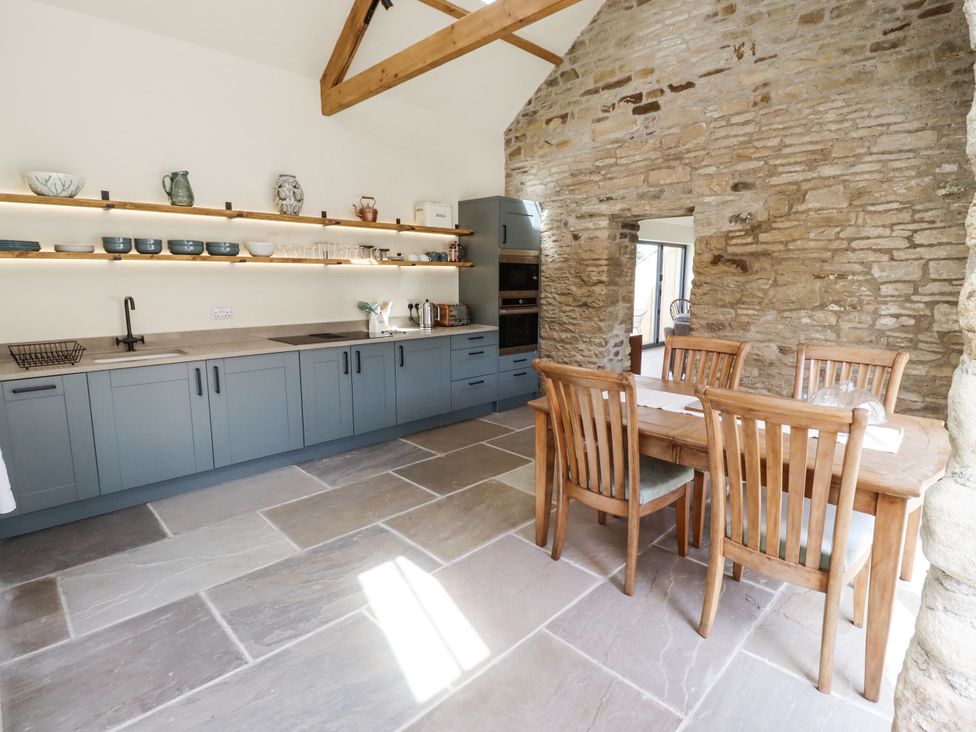 A kitchen with grey cabinets and a dining table at West Dunkirk Hemmels in Hexham