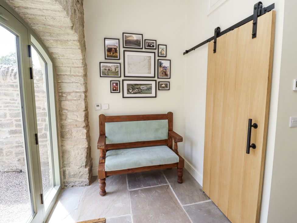An entrance hall with a bench and photo frames at West Dunkirk Hemmels in Hexham