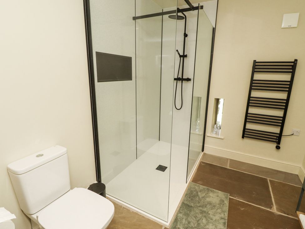 A bathroom with a shower, toilet, and towel radiator at West Dunkirk Hemmels in Hexham