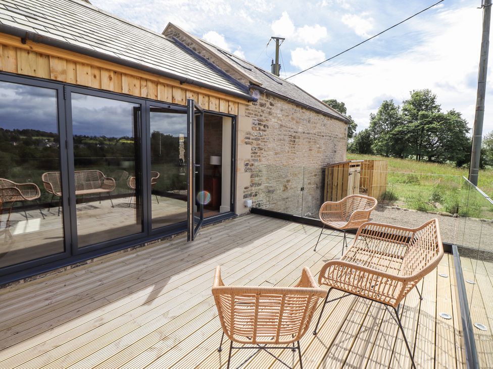 An outdoor patio with chairs and sliding doors at West Dunkirk Hemmels in Hexham