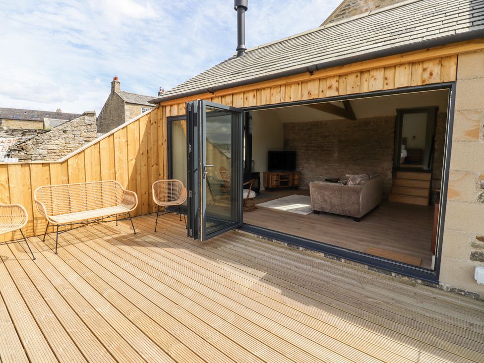 An outdoor deck with seating and a view into a living room at West Dunkirk Hemmels Hexham