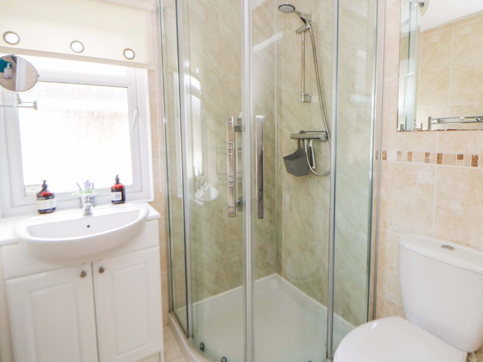 A bathroom with a shower, toilet, and sink at Erisa in Stepaside