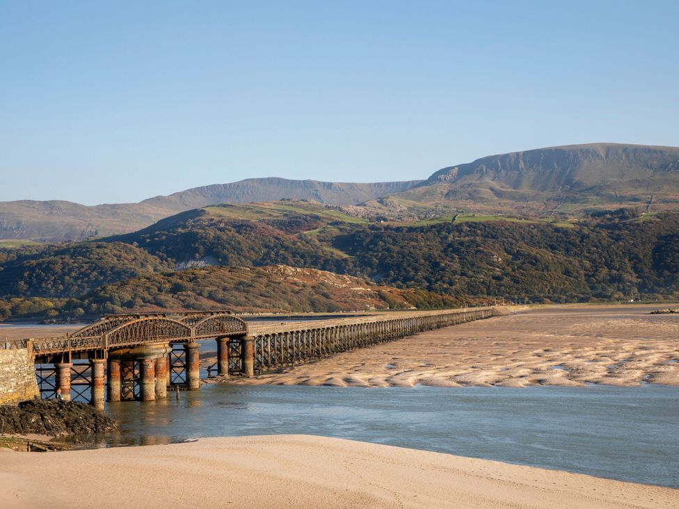 An iron railway bridge over a river with hills in the background at Celyn in Bontddu near Dolgellau