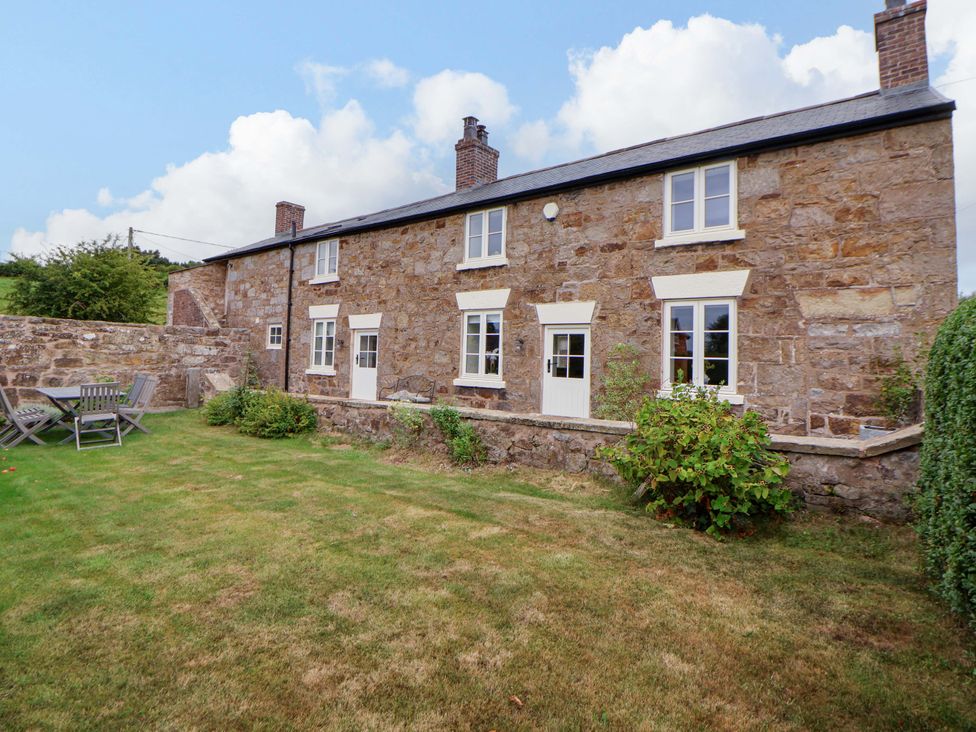 A house with a garden and seating area at Isfryn