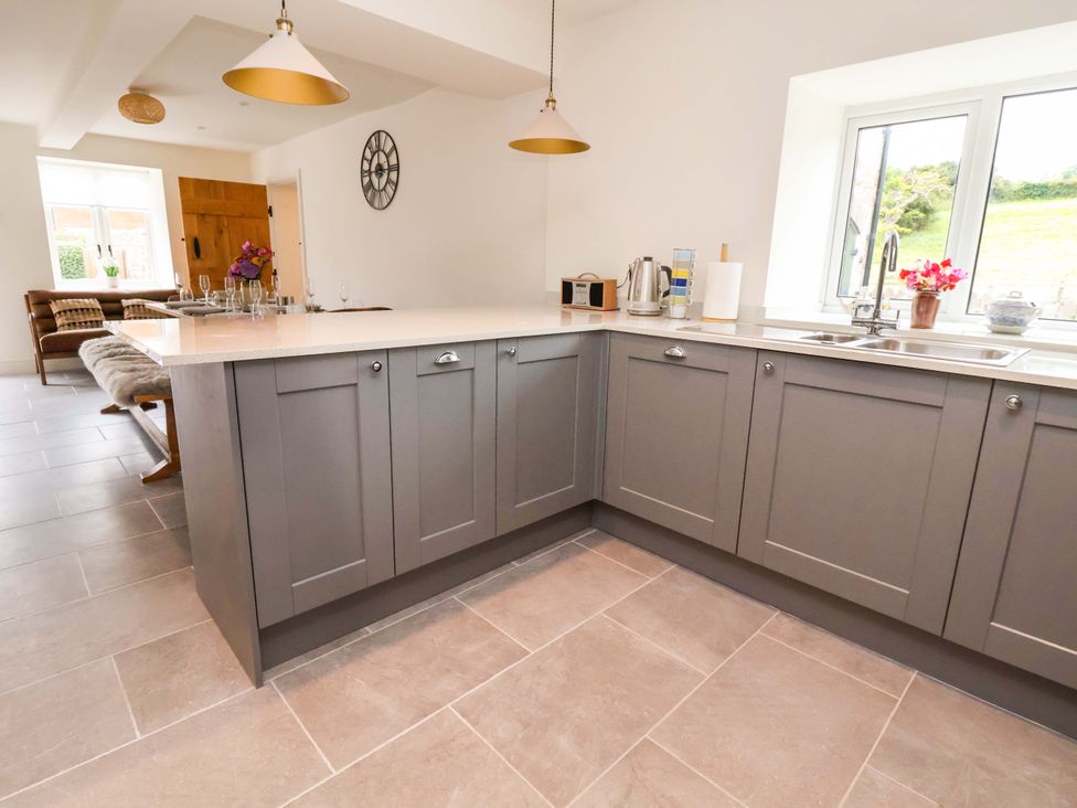 A kitchen with gray cabinets and a sink at Isfryn