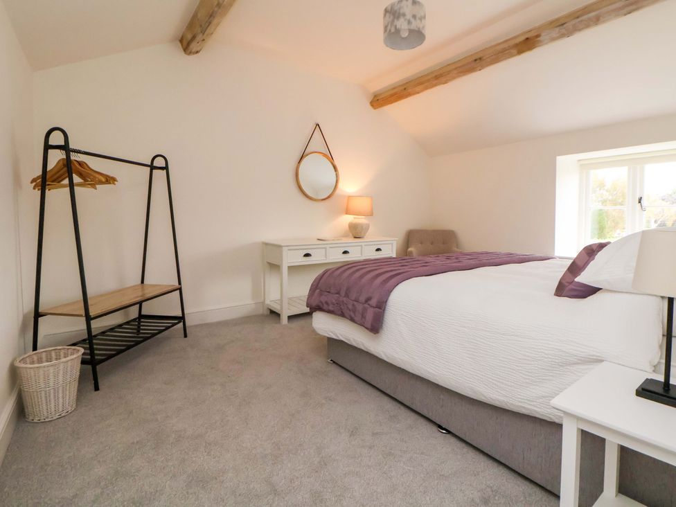 A bedroom with a bed and wardrobe rack at Isfryn