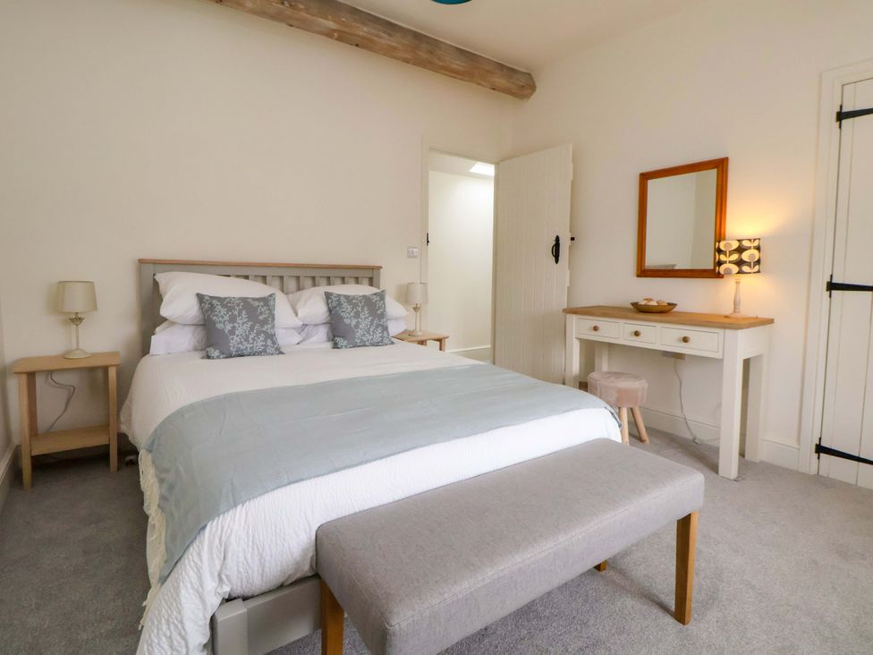 A bedroom with a bed, nightstand and dresser at Isfryn 