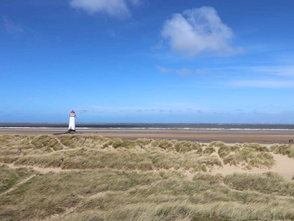 A lighthouse near the beach with sand dunes and ocean at Isfryn Nercwys