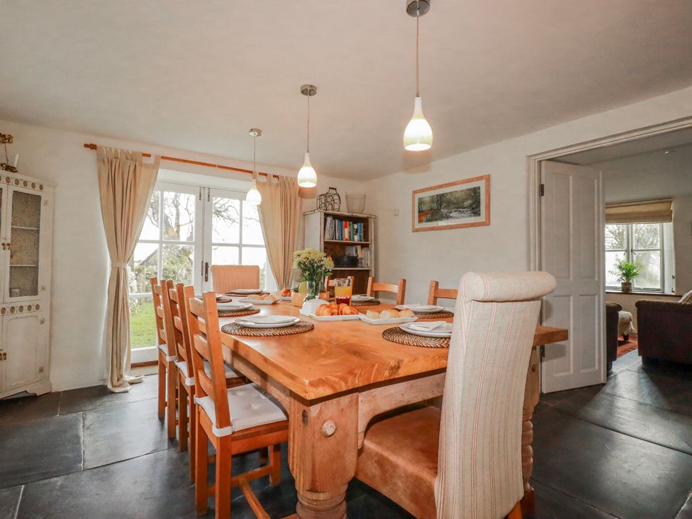 A dining room with a wooden table and chairs at Poldue House in Watergate near Camelford