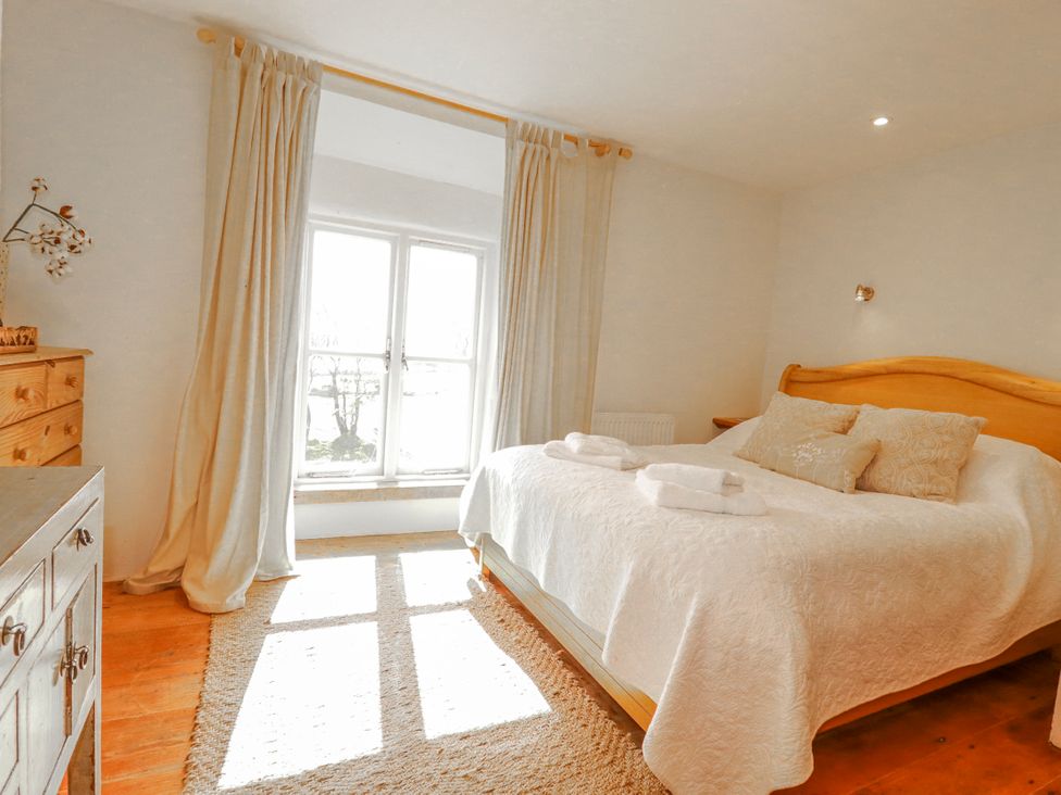 A bedroom with a bed and window light at Poldue House Watergate near Camelford