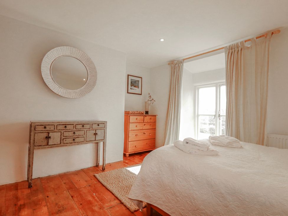 A bedroom with a bed and dresser at Poldue House Watergate near Camelford
