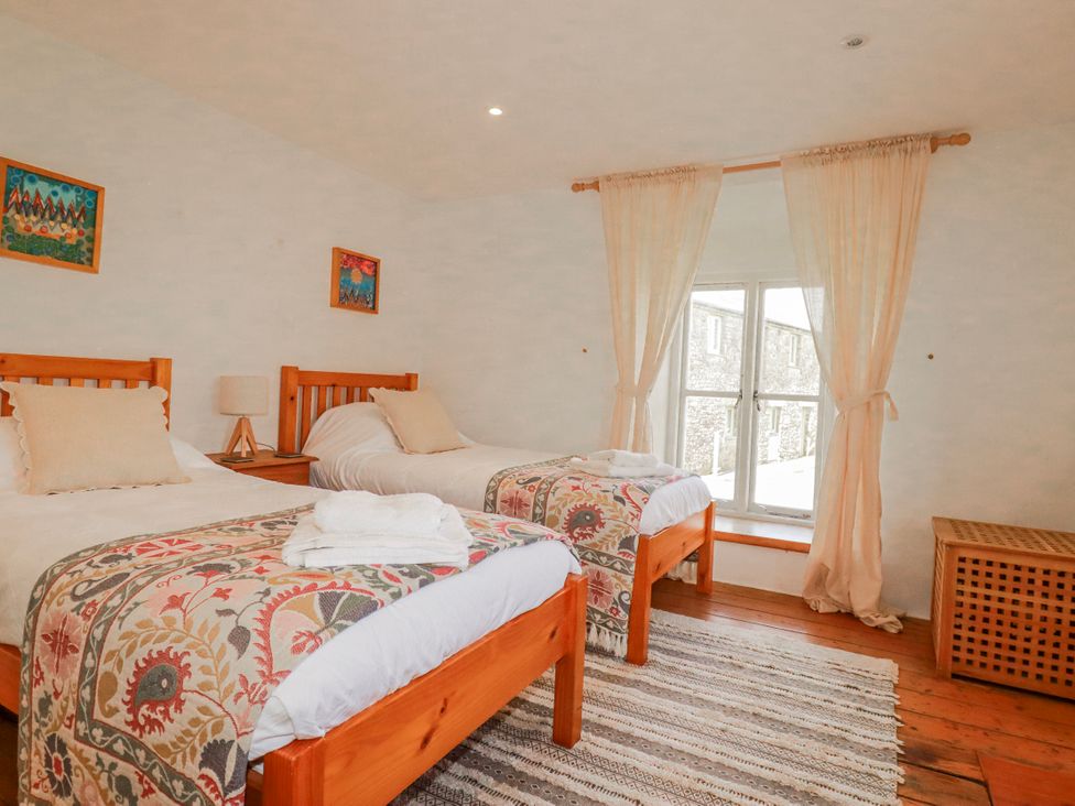 A bedroom with two beds and a window at Poldue House Watergate near Camelford