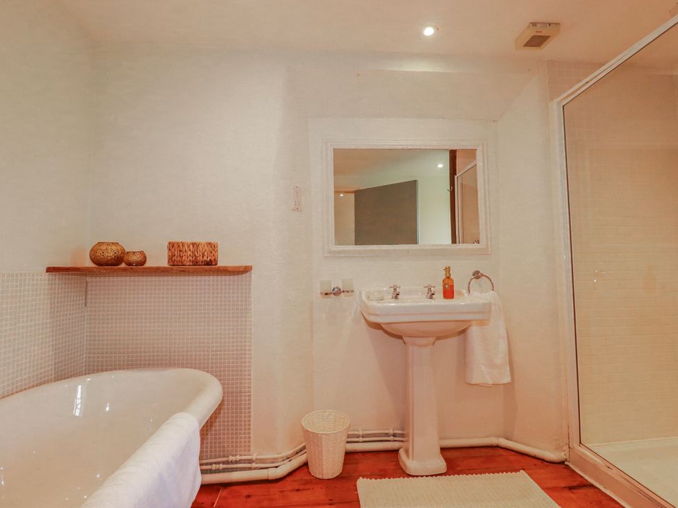 A bathroom with a bathtub, sink, and shower at Poldue House Watergate near Camelford