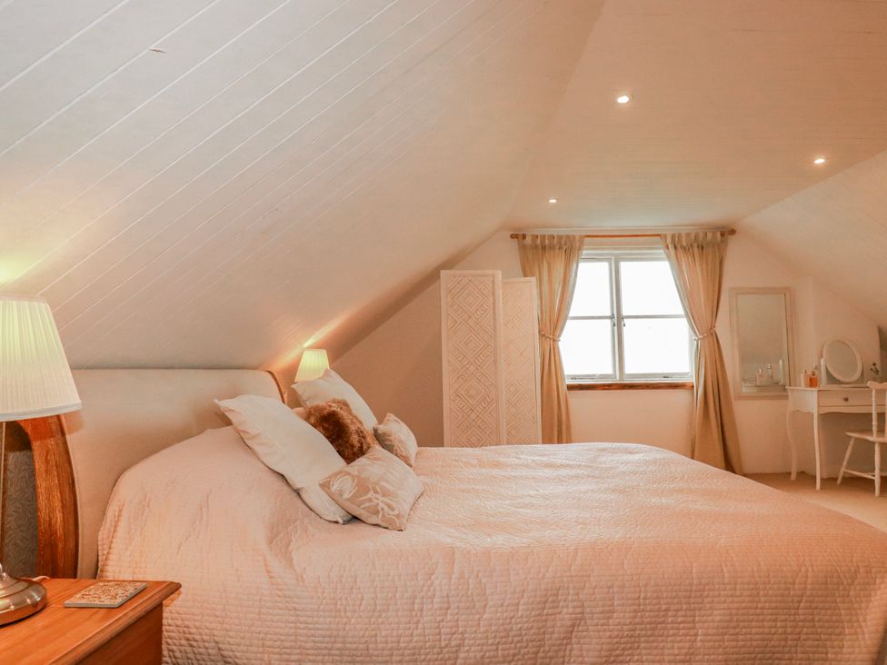 A bedroom with a bed and dressing table at Poldue House in Watergate near Camelford