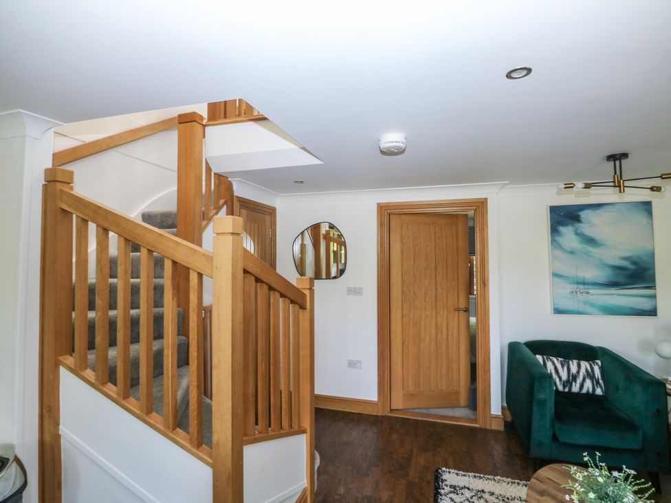 A hallway with stairs and a mirror at 2 Court Cottage in Dartmouth